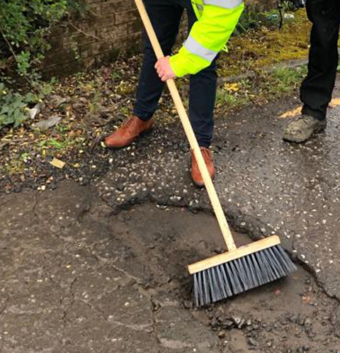 Step 1: sweeping loose debris out of the pothole